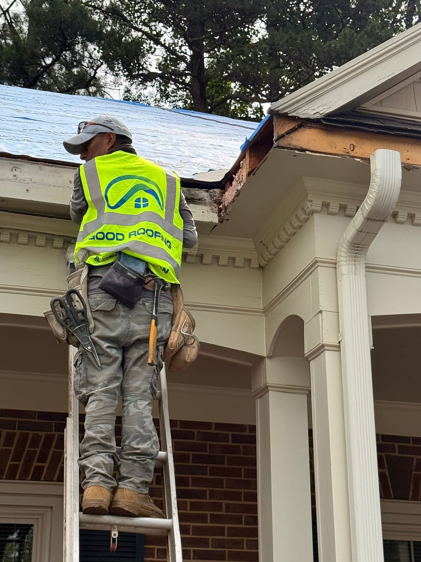 Roof technician examining shingles for damage